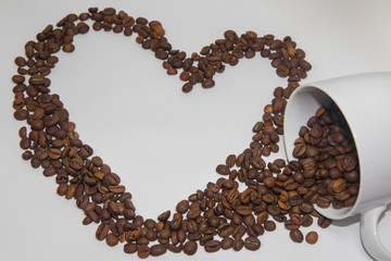 Spilled coffee beans from the white ceramic cup a beautiful patt