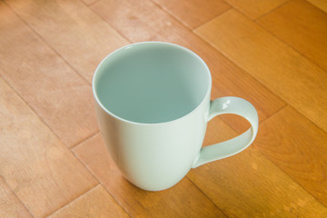 Empty coffee cup on wooden floor
