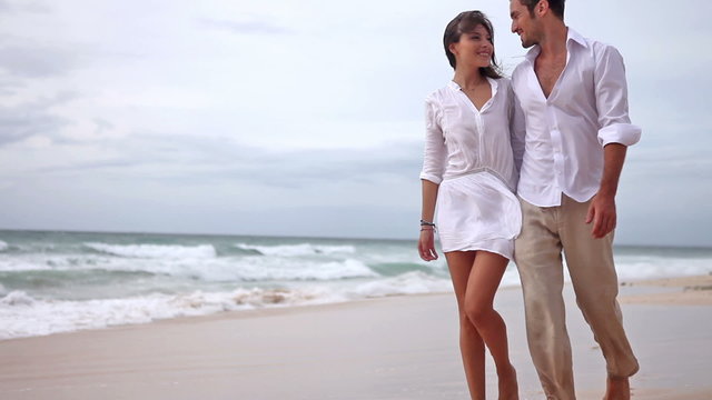 Happy couple in love having fun on the beach, slow motion,