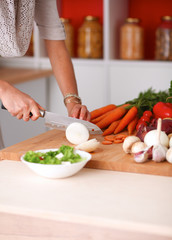 Young woman cutting vegetables in the kitchen