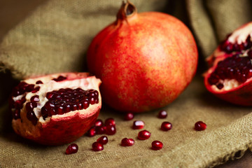 Raw red bright pomegranate with seeds on sacking background