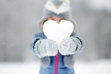 Funny little girl having fun in winter park