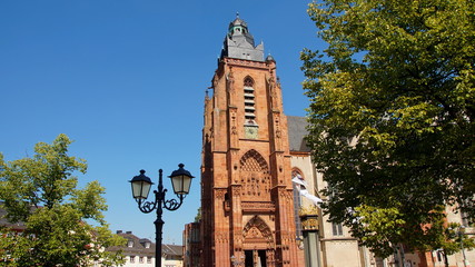 Fototapeta na wymiar Turm des Wetzlarer Doms vor blauem Himmel und grünem Baum