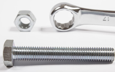 Screw, nut, wrench isolated on white