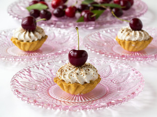Cupcakes (three cakes) with cherries and whipped cream