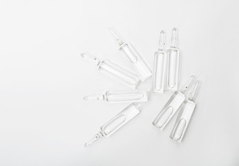 Top view of break-seal glass ampoule set with liquid medicine on white background.