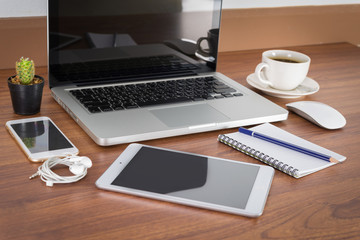 Laptop, smartphone, tablet and coffee cup with financial documen