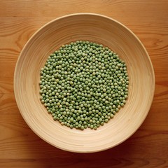 Bamboo Bowl with Green Peas on Wood Background
