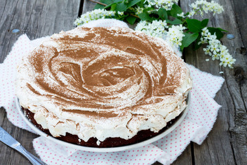 Cake chocolate-nut cake and meringue on wooden background