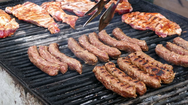 Romanian sausages (mici) and pork prepared on the grill. 4K.