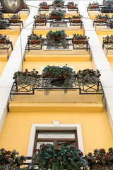 Yellow buildiing with many identical flower boxes
