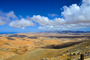 Volcanic mountains , blue sky and clouds over Atlantic ocean. Fu