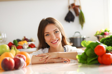 Young woman standing near desk in the kitchen