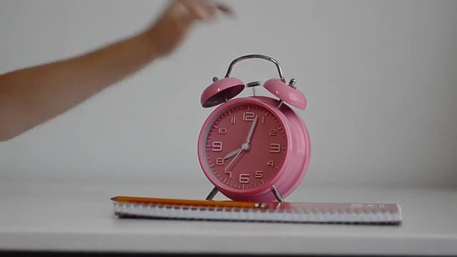 Alarm clock ringing child comically turning ringing bell off