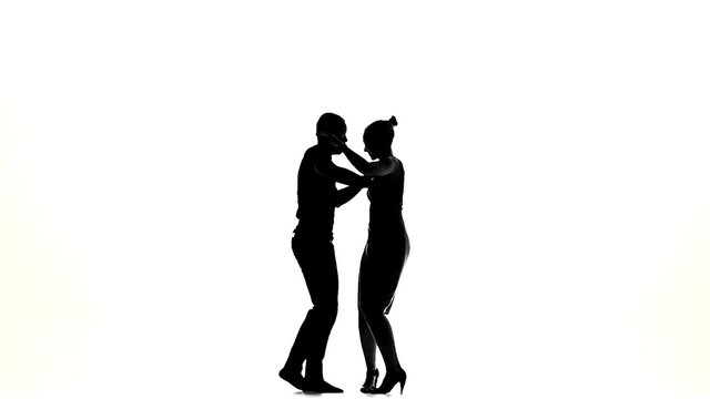 Two latino dancers finishing dancing, silhouette, on white, slow