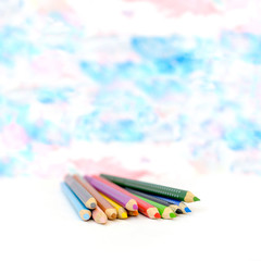 Colored pencils on blue blurred background
