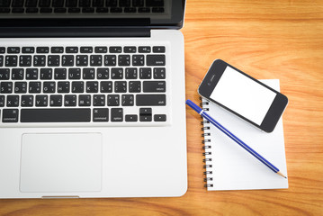 Laptop, smartphone and coffee cup with financial documents on wo