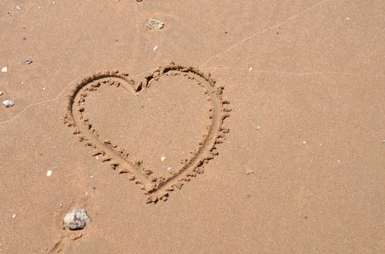 Heart carved into sand