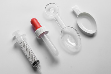 Different tools used for feeding liquid medicine to young baby