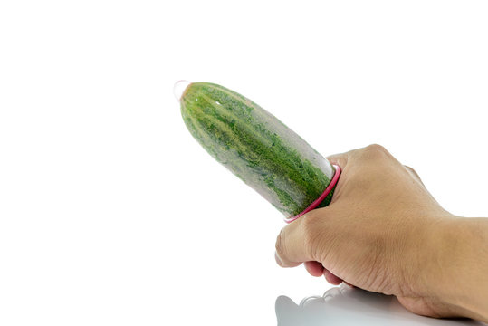 man's hand holding a cucumber with a condom