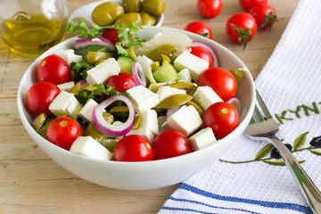 Greek salad in a bowl on a wooden table.