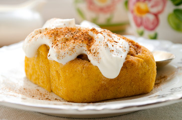 Homemade pumpkin cinnamon rolls with spices and sweet cream