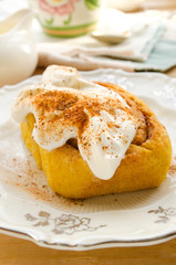 Homemade pumpkin cinnamon rolls with spices and sweet cream