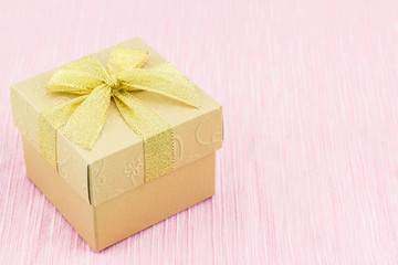 Golden gift box with ribbon bow.