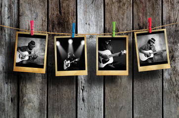 Guitarist photo hanging on clothesline on wood background.