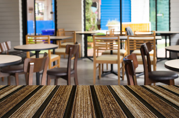 Selected focus empty brown wooden table and Coffee shop blur bac
