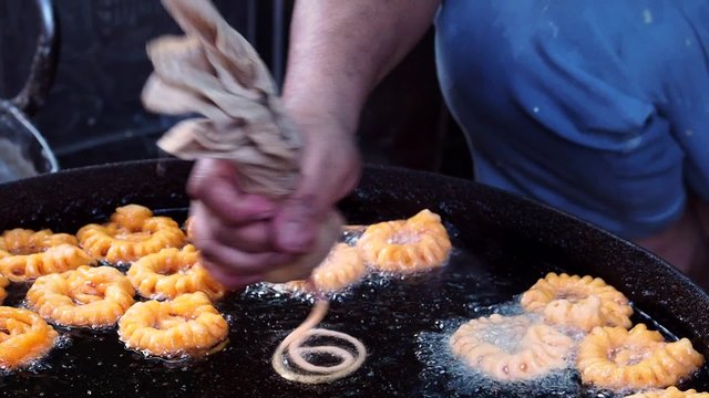 Street vendor frying typical Indian street pastry Imarti (Jaangiri or Jhangri in south India), a popular dessert invented in Mughal kitchen, in New Delhi, India. 