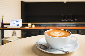 Hot art Latte Coffee in a cup on wooden table and Coffee shop bl