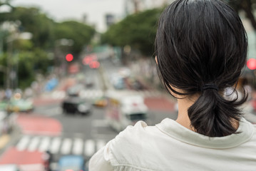 Naklejka premium 歩道橋の上から交差点を眺める女性