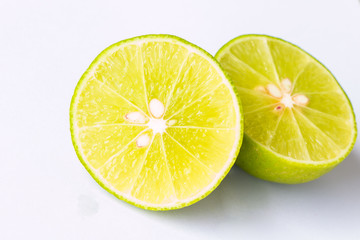 sliced green lime on a white background (half).