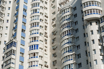 Fototapeta na wymiar The facade of white high-rise apartment building