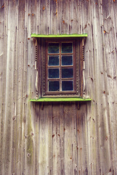 carved frame and window in the old wooden house from boards