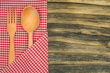 Kitchen tablecloth, fork, spoon on wooden table background