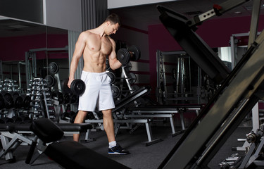 Fototapeta na wymiar Athletic strong bodybuilder execute exercise in sport gym hall