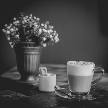 Hot art Latte Coffee in a cup on wooden table, black and white e