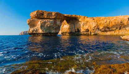 Azure Window, famous stone arch on Gozo island with reflection,