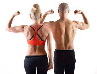 Athletic middle-age man and woman posing in studio. Back view.