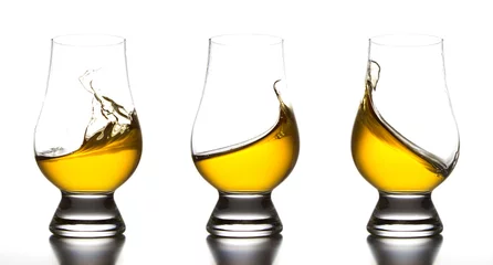 Papier Peint photo Lavable Alcool Yellow liquor in whiskey glass splash