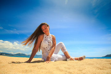 blonde girl in lace in yoga asana leg cross on beach