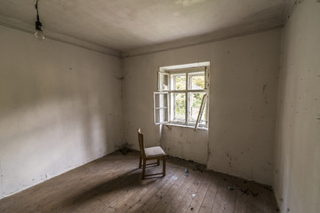 Kahler Raum mit Sessel und Fenster