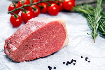 a pieces of fresh meat, beef slab, decorated with greens and vegetables