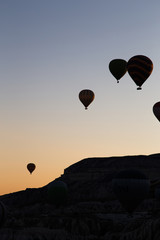 Ballons in the eraly morning over rocks in cappadocia