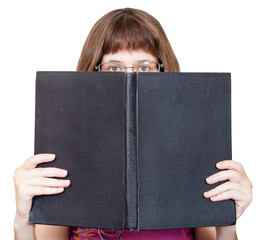 front view of girl with spectacles looks over book