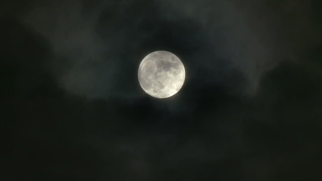A realtime shot of the full moon on a cloudy night. In 4K UltraHD. Not computer generated.	
