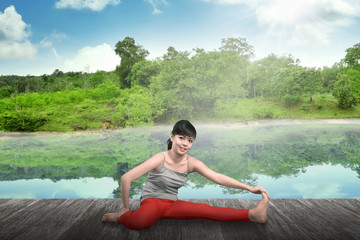 Fototapeta na wymiar Woman Doing Yoga At The Lake