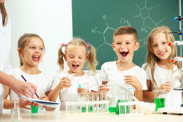 Cute pupils doing biochemistry research in chemistry class